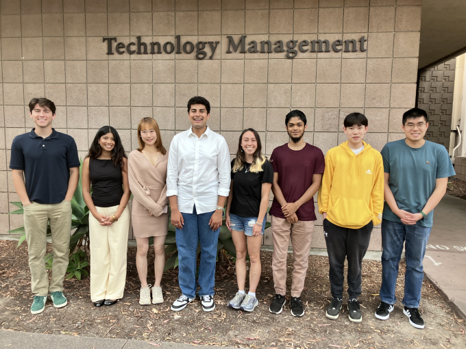 A photo of eight UCSB undergraduate students under a sign reading Technology Management.