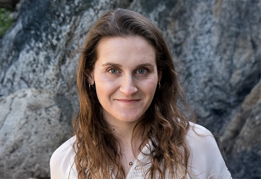 Headshot of a woman standing in front of a rock