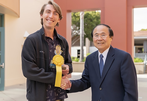 Chancellor Henry T. Yang (right) presents graduate student George Degen with first-place trophy and ribbon at the 2019 UCSB Grad Slam. Photograph by Jeff Liang