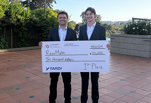 From left to right, Nico Lehner and Evan McCall, standing outside holding a large check for $10,000