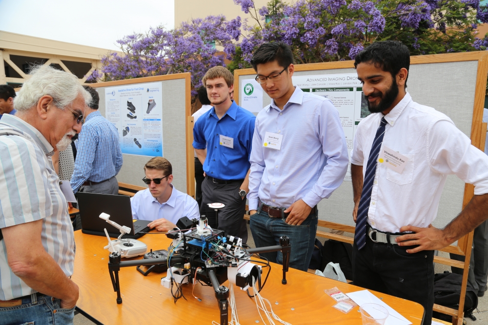Members of Advanced Image Droning demonstrate their project to a spectator